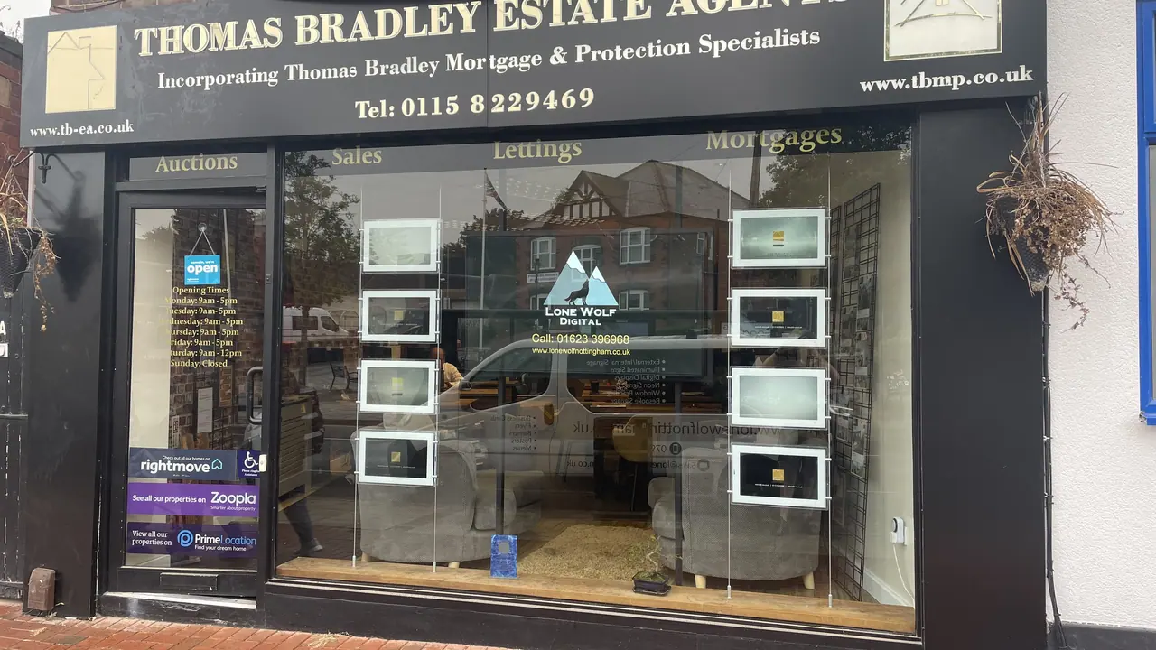 Estate agent shop window with illuminated window displays