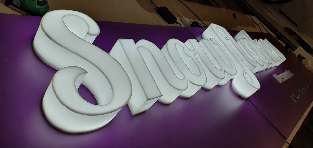White 3D acrylic letters on a purple wall